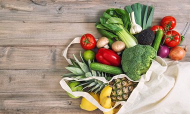 Sağlıklı yiyecekler. Taze sebzeler pamuk torbasında. Domates, salatalık, brokoli, ananas, avokado, muz, salata.