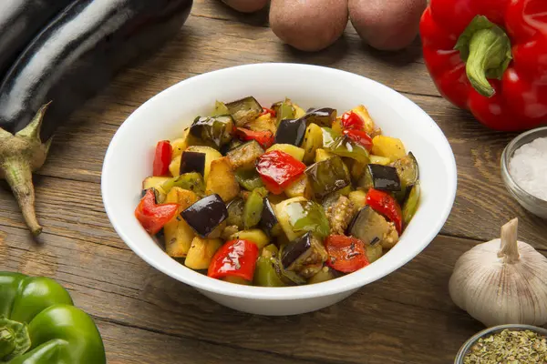 Kızarmış patlıcan, patates ve dolma biber kırsal ahşap bir masada malzemelerle..