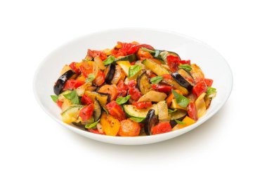 Beyaz arka planda izole edilmiş salata kasesinde sotelenmiş patlıcan kabağı havuç ve domates..