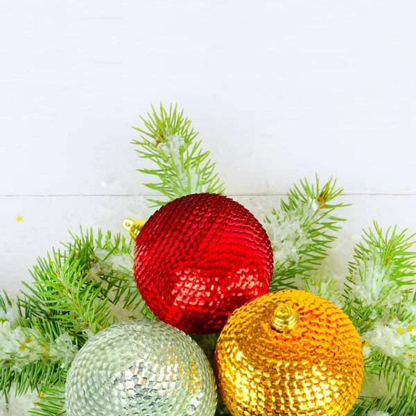 白い木製の背景にモミの小枝 クリスマスの多色のボールと雪 テキストのためのフリースペース — ストック写真