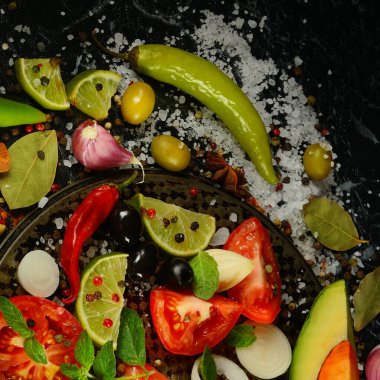 Siyah arka planda çeşitli baharatlar ve sebzeler..