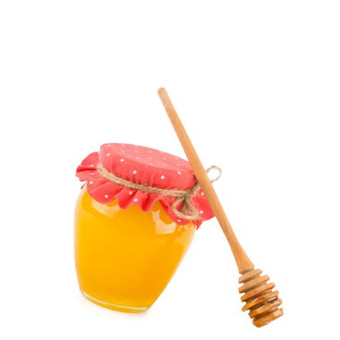 Honey in glass jar and wooden dipper isolated on white background. Free space for text.
