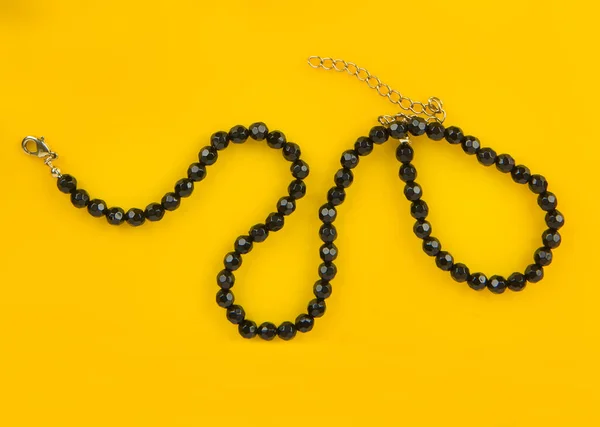 Parlak Sarı Arkaplanda Siyah Boncuklar Mücevherler — Stok fotoğraf