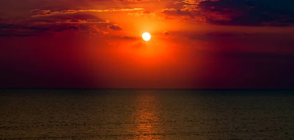热带海滩上明亮的红色日出 全息图 图库照片