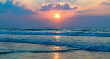 Tropik plaj, mavi deniz ve parlak günbatımı. Geniş resim.