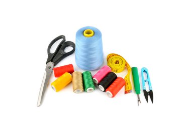 Dikiş malzemeleri (iplik, makas ve mezura) beyaz bir arkaplanda izole edildi.