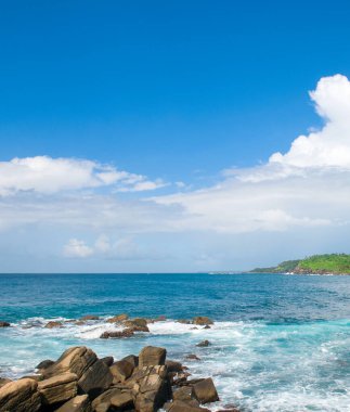 Manzaralı tropik plaj ve güzel bulutlu gökyüzü. Dikey fotoğraf.