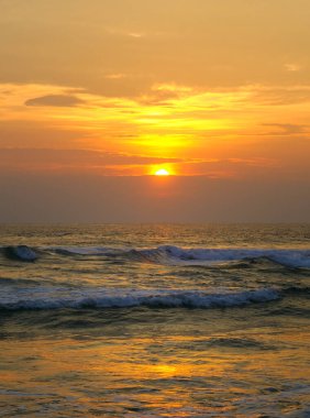Deniz ve parlak gün doğumu. Konsept - tatil ve seyahat. Dikey fotoğraf.