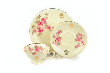 Beyaz arka planda izole edilmiş klasik porselen bardak ve çay tabağı..