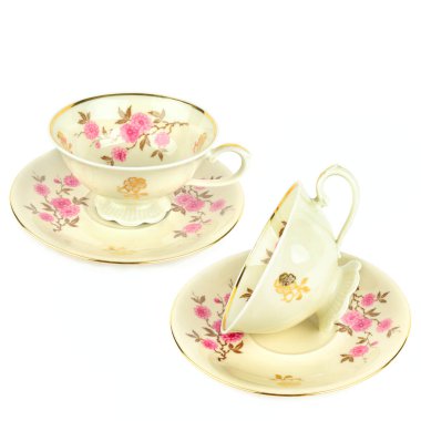 Beyaz arka planda izole edilmiş klasik porselen bardaklar ve çay tabağı. Kolaj. Metin için boş alan.