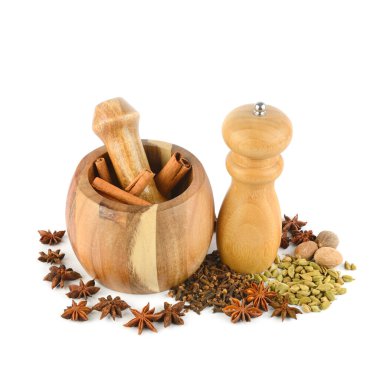 Biber öğütücü değirmeni, havan topu, tokmak ve baharat beyaz zemine saçılmış..