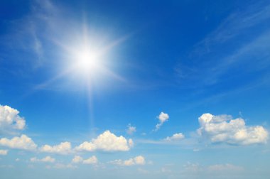 Mavi gökyüzü beyaz bulutlar ve parlak güneş.