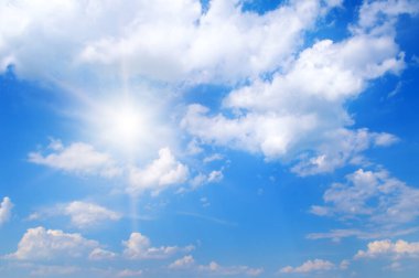 Mavi gökyüzü beyaz bulutlar ve parlak güneş.