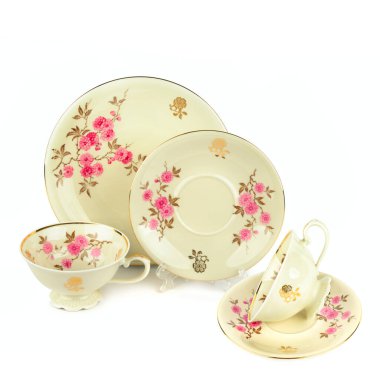 Beyaz arka planda izole edilmiş klasik porselen bardaklar ve çay tabakları. Metin için boş alan. Kolaj.