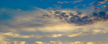 Bulutlu gökyüzü ve ufuk üzerinde parlak gündoğumu. Geniş fotoğraf.