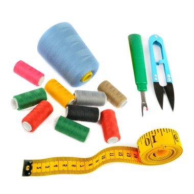 Dikiş malzemeleri (iplik, makas ve mezura) beyaz arka planda izole edilmiştir. Kolaj.