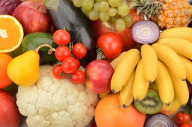 Çok çeşitli taze meyve ve sebzelerden oluşan canlı ve yakın plan bir kompozisyon. Bu görüntü sağlıklı ve sağlıklı bir yaşam tarzını, diyeti ve bol besinleri temsil eder..