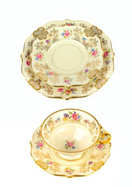 Zarif bir porselen çay seti. Karmaşık altın detaylarıyla ve temiz beyaz arka planda izole edilmiş narin çiçek desenleriyle. Bu rafine görüntü klasik stil ve geleneği, yaratıcı metin örtüleri için geniş bir alana sahip olarak aktarır. Dikey fotoğraf