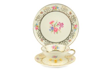 Güzel, kaliteli bir porselen çay seti, içinde bir fincan, çay tabağı ve hassas çiçek desenleri olan bir tabak ve altın bir kenar beyaz arka planda duruyor. Bu zarif görüntü gelenek, lüks ve güzel bir akşam yemeği duygusunu çağrıştırıyor..