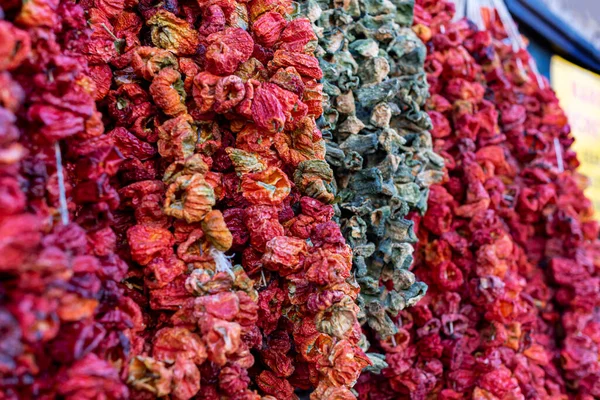 Red and green peppers  hanged on a market stall, close up