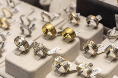 Altın alyanslar bir kuyumcunun penceresindeki rafta, yakın plan, açık hava fotoğrafçılığı. Trkiye Adana şehrinde 05.16.2023