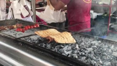 Geleneksel Adana kebabı turuncu renkli alev ve Adana yemek festivalinde sigara ile barbekü yapıyor. 10.08.2023