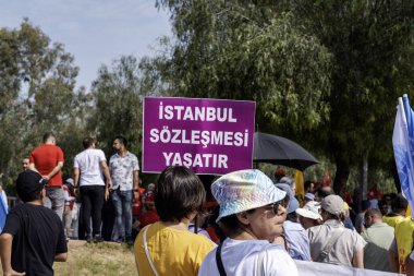 Türkiye 'nin Adana ilinde 1 Mayıs İşçi Bayramı' nda kadın protestocular Türkçe 'de' Konvansiyon Hayatta Kaldı 'tabelasını taşıyorlar. 05.01.2024