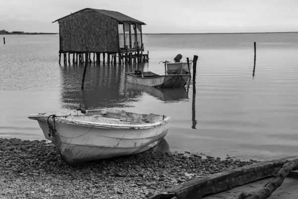 Soğuk bir günde deniz kenarında balıkçı tekneleri, siyah beyaz fotoğrafçılık, manzara fotoğrafçılığı.