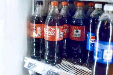 Coca Cola içkileri ve Pepsi marka kokaini marketin buzdolabının üstünde, kapat. 04.20.2024