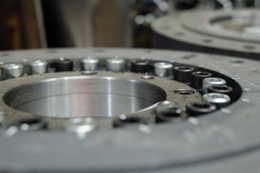 Macro shot of huge round detail or spare part for industrial or construction machine made up of stainless steel