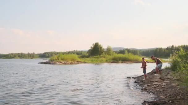 Extreme Wide Young Father Teenage Son Throwing Rocks Lake Standing — Stock videók