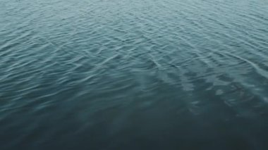 View of blue water surface of lake with small ripple on sunny summer day