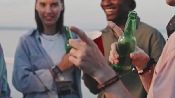 Cropped Guy Drinking Beer Bottle Gesticulating Talking Blurred Friends Outdoor — Vídeo de Stock