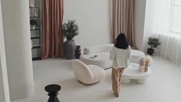 Wide Locked Asian Businesswoman Walking Sitting Couch Minimalist Apartment Drinking — Vídeo de Stock