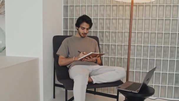 Medium Long Middle Eastern Young Man Sitting Living Room Modern — Stockvideo