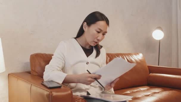 Medium Lama Wanita Asia Yang Sukses Duduk Sofa Coklat Rumah — Stok Video