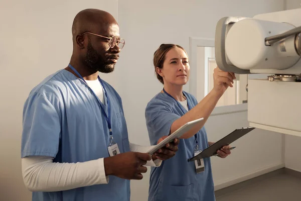 Two Young Interracial Clincians Uniform Switching Medical Equipment While Female — Stockfoto
