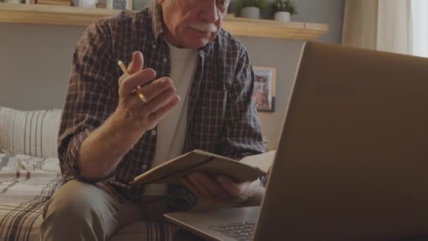 Tilting Energetic Senior Caucasian Man Sitting His Bedroom Daytime Video — стоковое видео