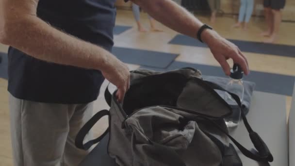 Tilting White Haired Caucasian Man Unpacking Sports Bag Fitness Studio — Stockvideo
