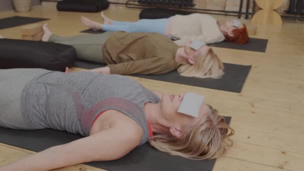 Tracking Mature Women Lying Backs Floor Modern Yoga Studio Meditating — Stok video
