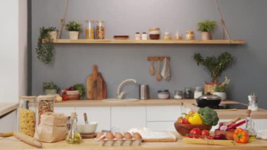 Medium shot of table with ingredients for cooking food on it in kitchen with no people there