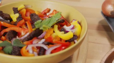 Close up tracking shot of food ingredients for cooking mexican tacos cooked meat strips with bell pepper slices, salsa sauce and flour tortillas