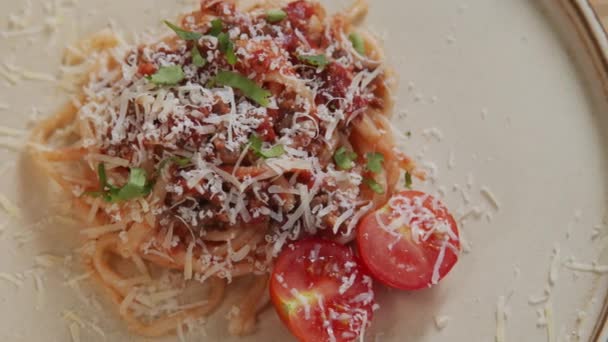 自家製スパゲティボローニャのトップダウンショットは 新鮮なチェリートマトと上にすりおろしたチーズとプレート上に提供しています — ストック動画