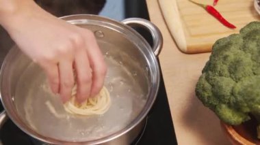 Close up tracking shot of cooking nests of fresh homemade pasta in pot with boiling water