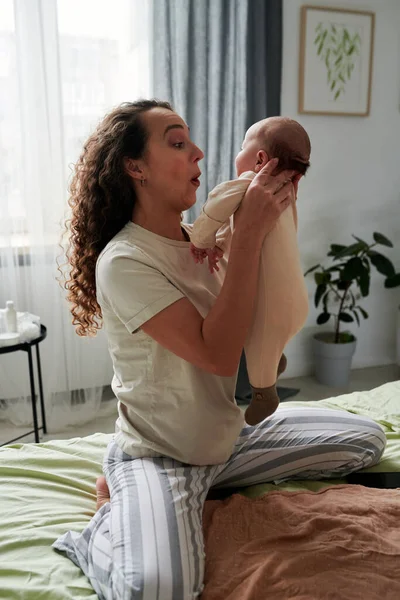 Young Female Pajamas Holding Her Adorable Baby Son Playing Him — стоковое фото