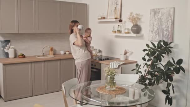 Medium Long Young Biracial Woman Loungewear Holding Adorable Infant Standing — стоковое видео