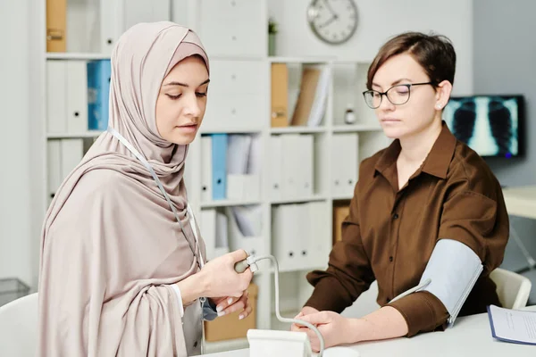 Young Muslim Female Physician Hijab Checking Blood Pressure Patient While — Stock Photo, Image