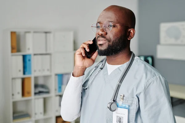 Självsäker Manlig Läkare Med Stetoskop Halsen Pratar Med Patienten Mobiltelefon — Stockfoto