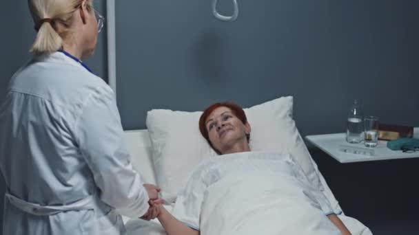 Medium Blond Haired Female Doctor Holding Hand Red Haired Senior — Video