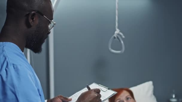 Shoulder Young Black Male Nurse Blue Scrubs Filling Medical Record — Video